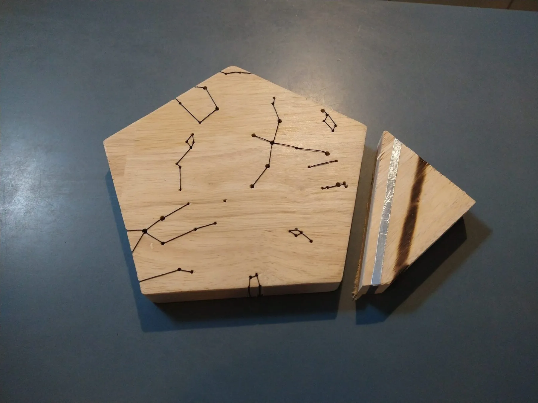 Close-up of a pentagon with constellations engraved and stitched